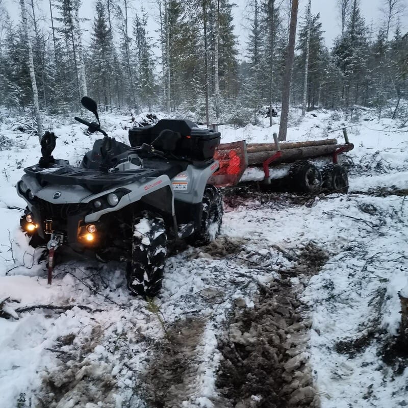 Mönkijä ja puukärry lumisella hakkuualueella