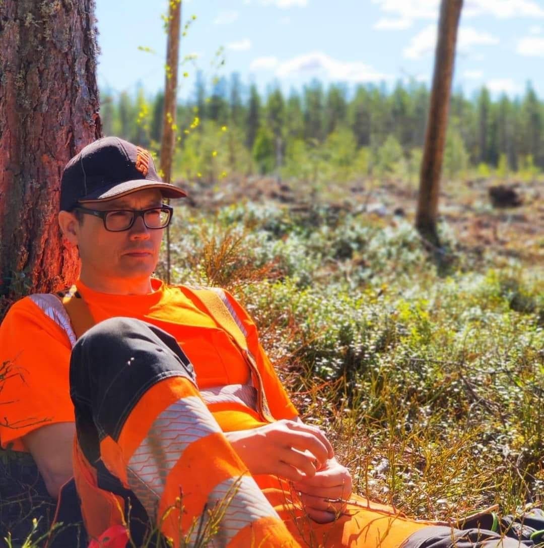 Yrittäjä tauolla puuta vasten kesäisellä uudistusalalla